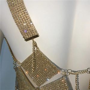 Detailed macro view of gold metal sequins and rhinestone embellishments on body chain top