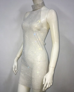 Gros plan des strass brillants sur la mini robe dos nu en résille vue de profil à 45 degrés