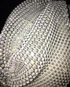 Macro shot of high-quality white beaded mesh with sparkling crystal rhinestones for hats