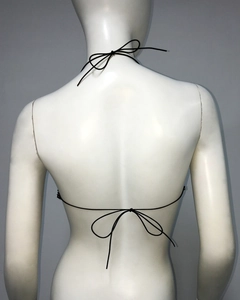 Detail of black rhinestone fishnet top featuring adjustable neck and back tie closures