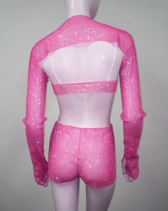 Rear view of bright pink rhinestone fishnet set with long sleeve crop top and shorts