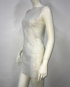 Détail d'une robe en strass argentés avec découpes latérales et lacets blancs croisés