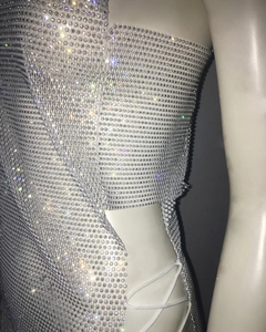 Détail de la robe en maille strass avec découpes latérales et fermeture à lacets blancs
