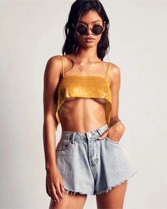 Détail d'un crop top à paillettes dorées avec une texture de maille d'aluminium scintillante