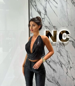 Detail of black sequin metal mesh halter top with deep V-neck and shimmery chainmail texture