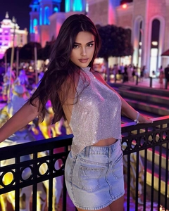 Sparkling silver rhinestone halter top paired with denim skirt under neon city lights