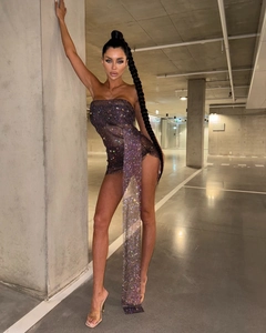 Détail d'une mini-robe pailletée à épaules dénudées avec strass brillants et longue écharpe