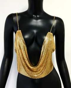 Detailed view of shimmering gold sequin mesh and metallic chain straps on low-cut top