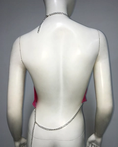 Détail du haut dos nu en maille à paillettes roses avec fines chaînes en métal argenté