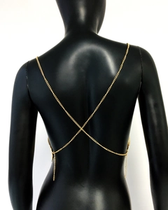 Detail view of a gold metallic chain body top with cross-back design on a model