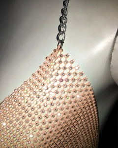 Détail du haut en maille à paillettes roses avec strass scintillants et chaînes en métal