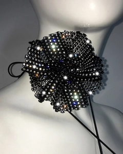 Détail d'un ras-du-cou camélia en maille noire avec strass scintillants sur un mannequin