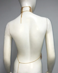 Detail of gold metal mesh body chain and rhinestone choker on a female model back