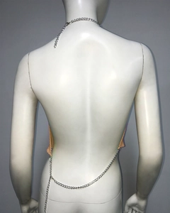 Détail d'un haut dos nu sexy en résille orange avec chaînes de corps en strass métal
