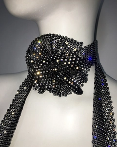 Détail d'un choker en résille noire orné de strass et d'un accent floral en 3D