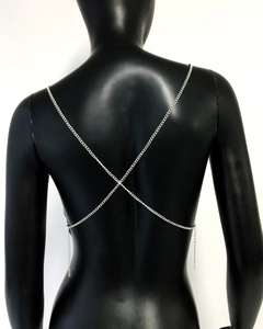 Detail of silver crisscross body chain on back featuring adjustable metal links