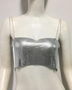 Détail d'un top court à paillettes argentées avec maille métallique et fines chaînes