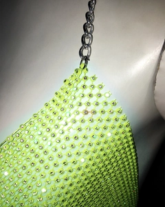 Détail du haut en résille vert néon avec strass et chaîne argentée sur mannequin blanc
