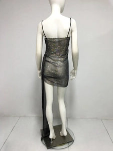 Détail d'une robe en résille noire avec strass brillants et ourlet long irrégulier