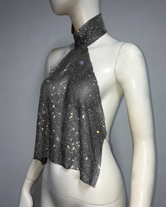 Detail of metallic mesh fabric and sparkling rhinestones on halter neck crop top