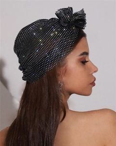 Détail du turban élastique noir orné de strass avec un grand nœud étincelant