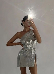 Detail of silver metallic sequin fabric on one-shoulder dress with a high side slit