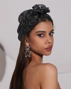 Détail d'un turban noir à strass et boucles d'oreilles pendantes à double étoile