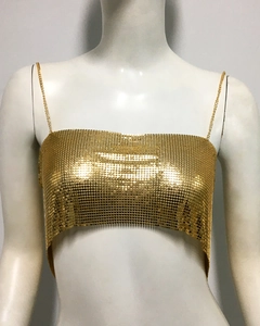 Détail du haut en maille métallique à paillettes dorées avec fines bretelles chaîne