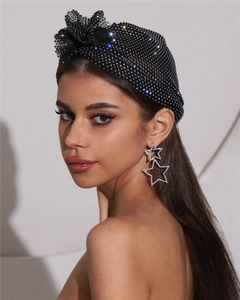 Gros plan sur foulard résille noir à strass et boucles d'oreilles étoiles pendantes