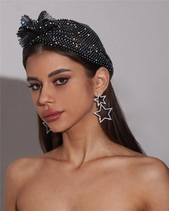Détail du foulard noir en strass et des boucles d'oreilles en cristal en forme d'étoile