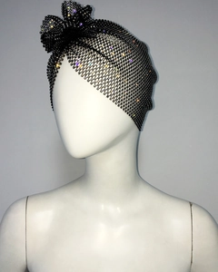 Détail de coiffe en résille noire avec strass multicolores et nœud décoratif