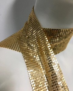 Close-up of gold metal sequin choker featuring a hexagonal mesh pattern and fabric-like texture