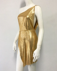 Detailed view of golden metal mesh texture and chain link waist on a one-shoulder dress