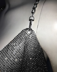 Détail macro du haut à paillettes argentées avec strass brillants et fermoir mousqueton
