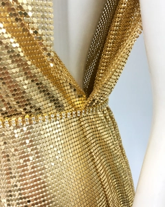 Detailed macro view of golden metal mesh fabric with sparkling rhinestone waist trim