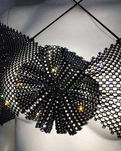 Close-up of a sparkling black rhinestone mesh camisole top featuring a large bow design