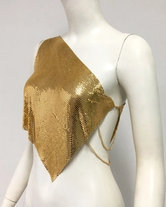 Détail du top dos nu à paillettes dorées avec bretelles chaîne et ourlet asymétrique