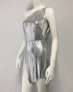 Detail of silver metal mesh dress featuring asymmetrical hem and waist chain embellishment