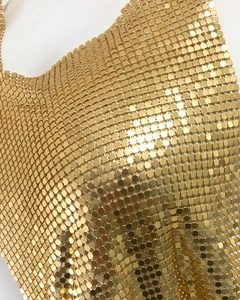 Gros plan sur un tissu en maille métallique dorée avec des paillettes carrées brillantes