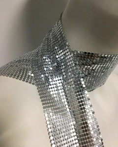 Close-up of shimmering silver metal sequin mesh scarf with reflective hexagonal links