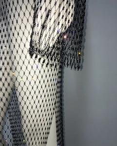 Close-up of black mesh dress featuring intricate beadwork and sparkling rhinestones