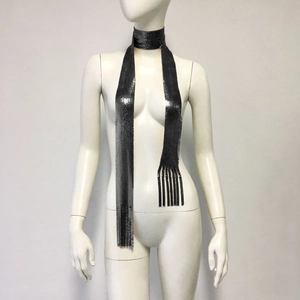 Detailed close-up of dark silver metal sequin scarf with long tassel on a white mannequin