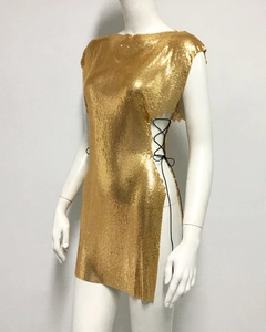 Détail de la mini-robe à paillettes dorées avec laçage latéral et texture cotte de mailles