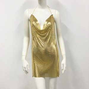 Close-up of golden metallic sequin mesh fabric on a deep V-neck halter mini dress