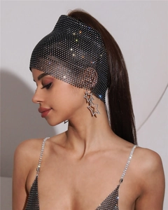 Détails de strass brillants sur une coiffe en résille noire et boucles d'oreilles