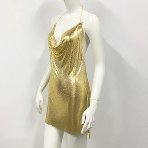 Close-up of gold metal sequin mesh fabric on a sexy halter backless party mini dress