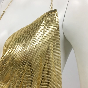 Detailed view of shimmering gold sequin mesh and chain neck strap on a party dress