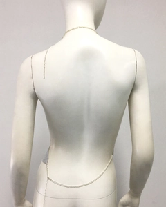 Détail de la chaîne de dos à paillettes métalliques argentées sur un haut en maille