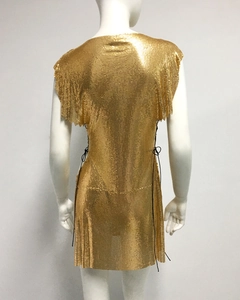 Détail d'une robe dorée à paillettes métalliques avec cordon de serrage et dos nu