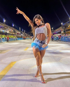 Détail d'un haut en strass argenté et short en jean avec bordure en plumes bleues